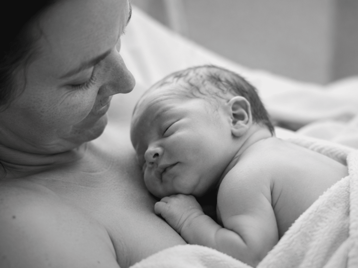 Newborn baby resting skin-to-skin on their mother’s chest shortly after birth, capturing a calm and connected first moment together.